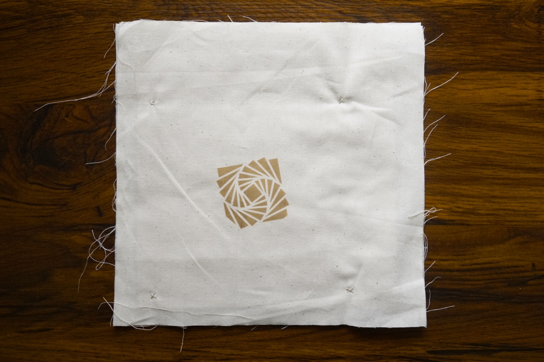 the final piece, a square piece of muslin with a laser engraved logo on it