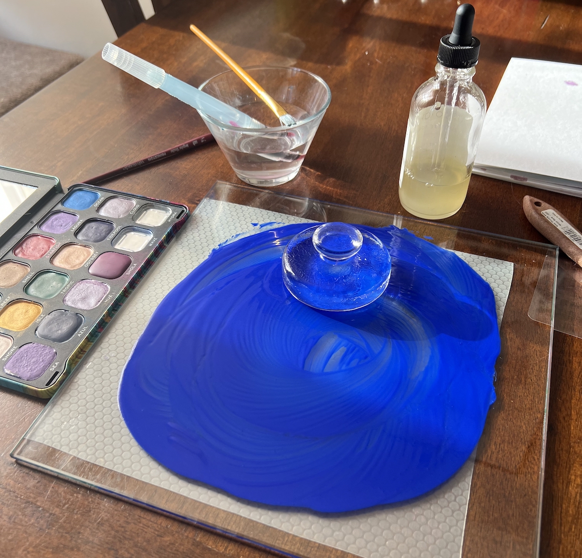 photo of my watercolor gear and i'm halfway through mulling a deep blue paint