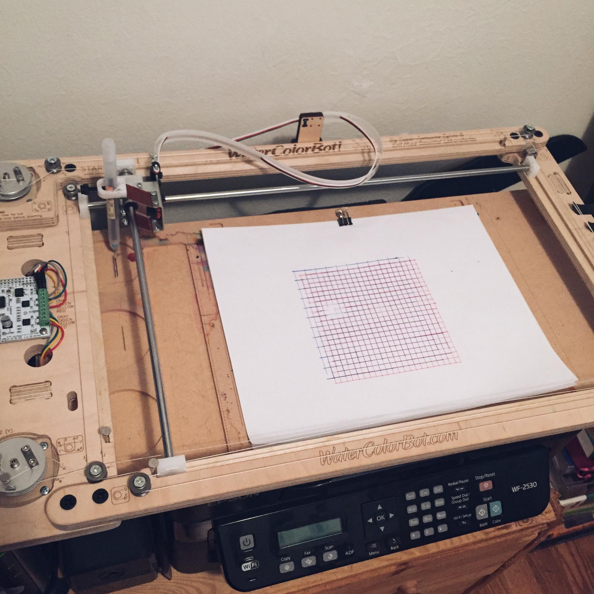 photo of a watercolorbot and the drawing is of two grids on top of each other, one blue and the other red