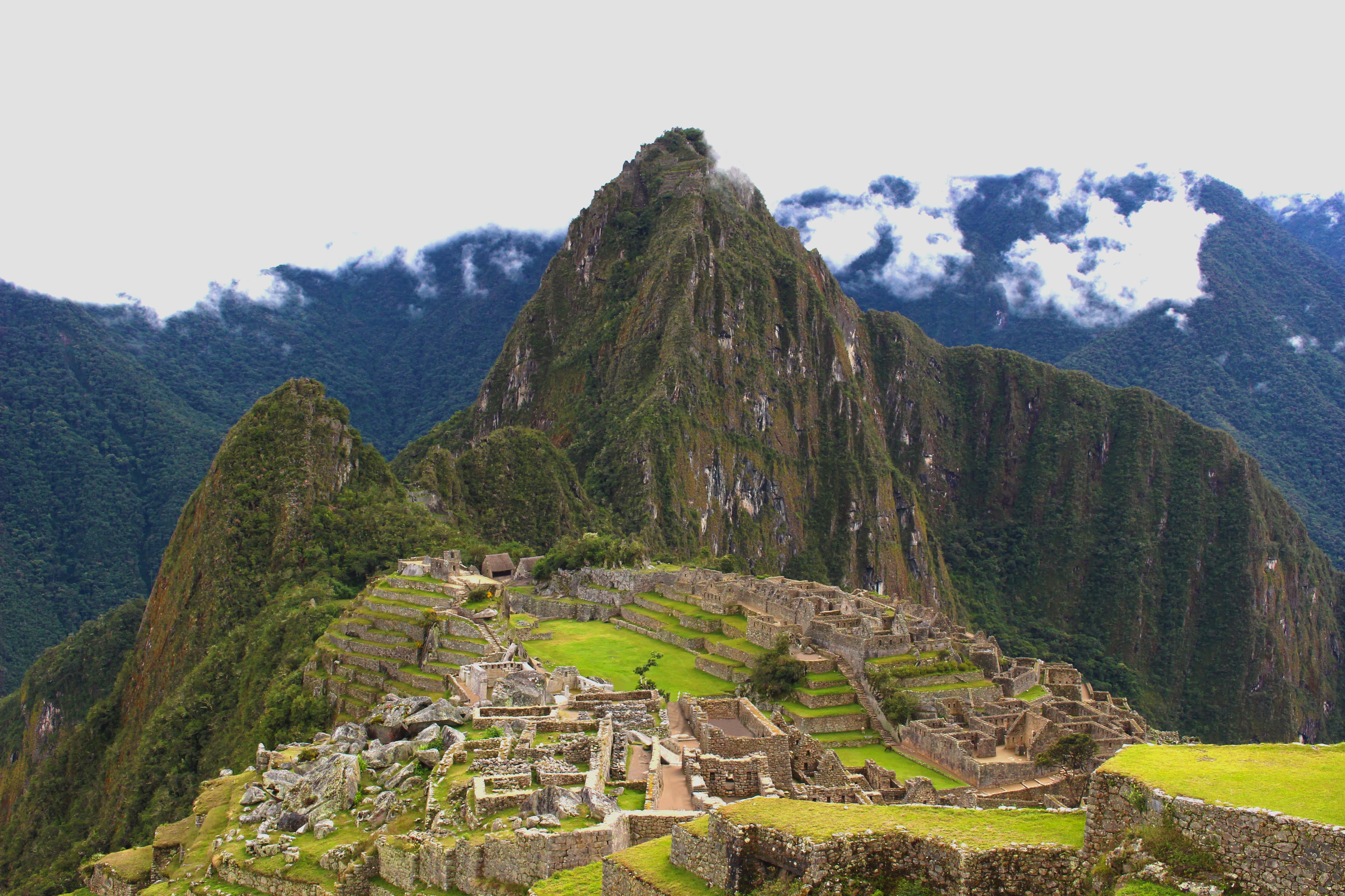 photo of Machu Picchu in Peru with some early morning fog surrounding the top of the mountains.