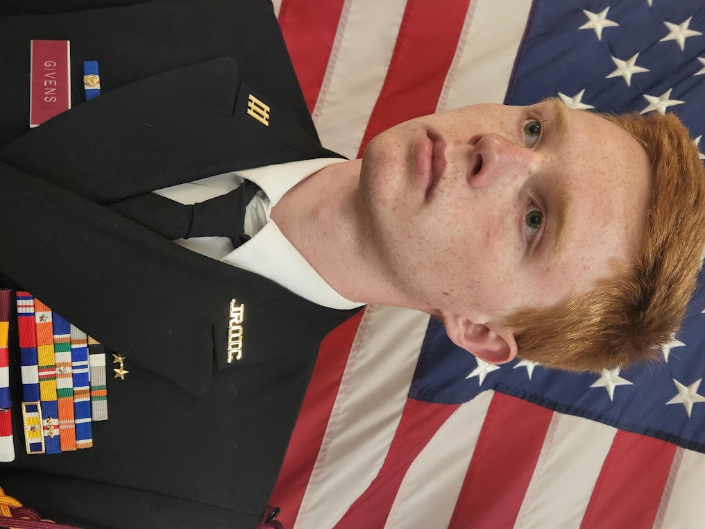 Picture of Tristan Givens standing in front of the American flag with his dress blues on