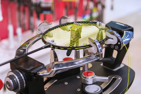 A badminton racket on a restringing machine